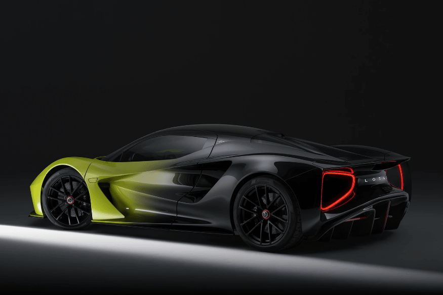 Lotus Evija preto com detalhes em verde-limão posicionado em estúdio escuro com iluminação lateral.