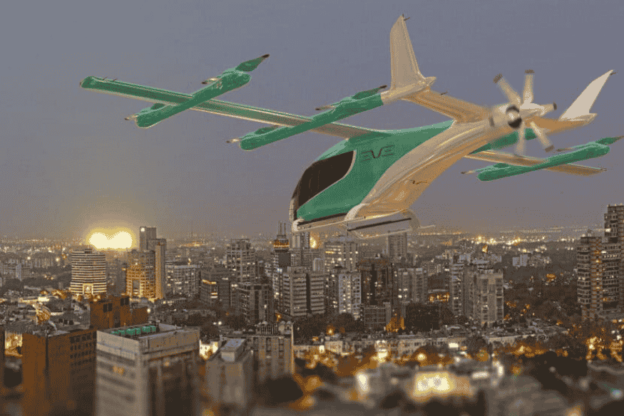 eVTOL da Eve Air Mobility voando sobre cidade ao entardecer, representando o futuro da mobilidade aérea urbana.