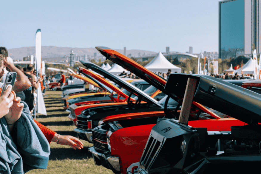 Pessoas fotografando carros antigos em evento ao ar livre