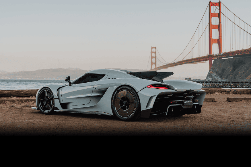 Koenigsegg Jesko Absolut estacionado em frente à ponte Golden Gate, com visual elegante e aerodinâmica refinada.