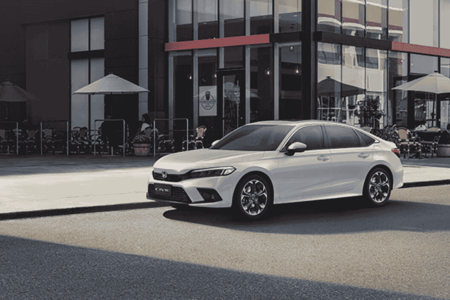 Honda Civic branco estacionado em frente a um café moderno ao ar livre.