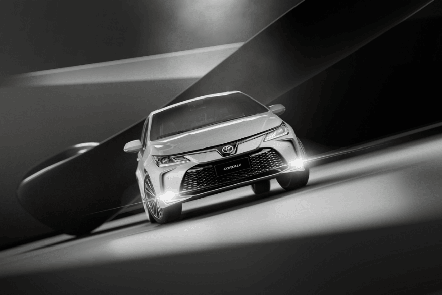 Toyota Corolla em estúdio com iluminação artística em preto e branco.
