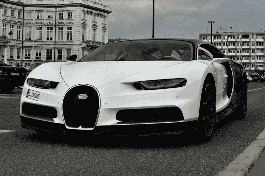 Bugatti Chiron branco estacionado em rua urbana com prédios ao fundo